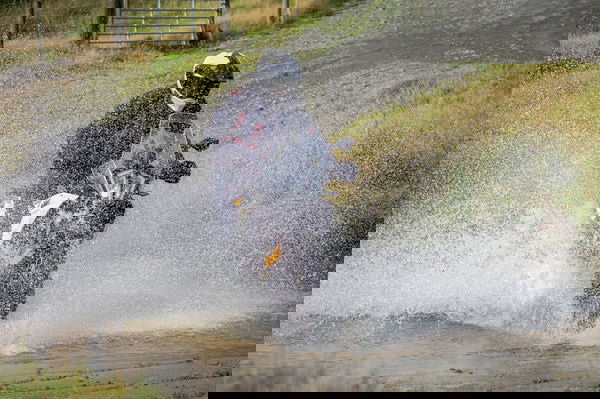 A KTM adventure motorcycle fording a river